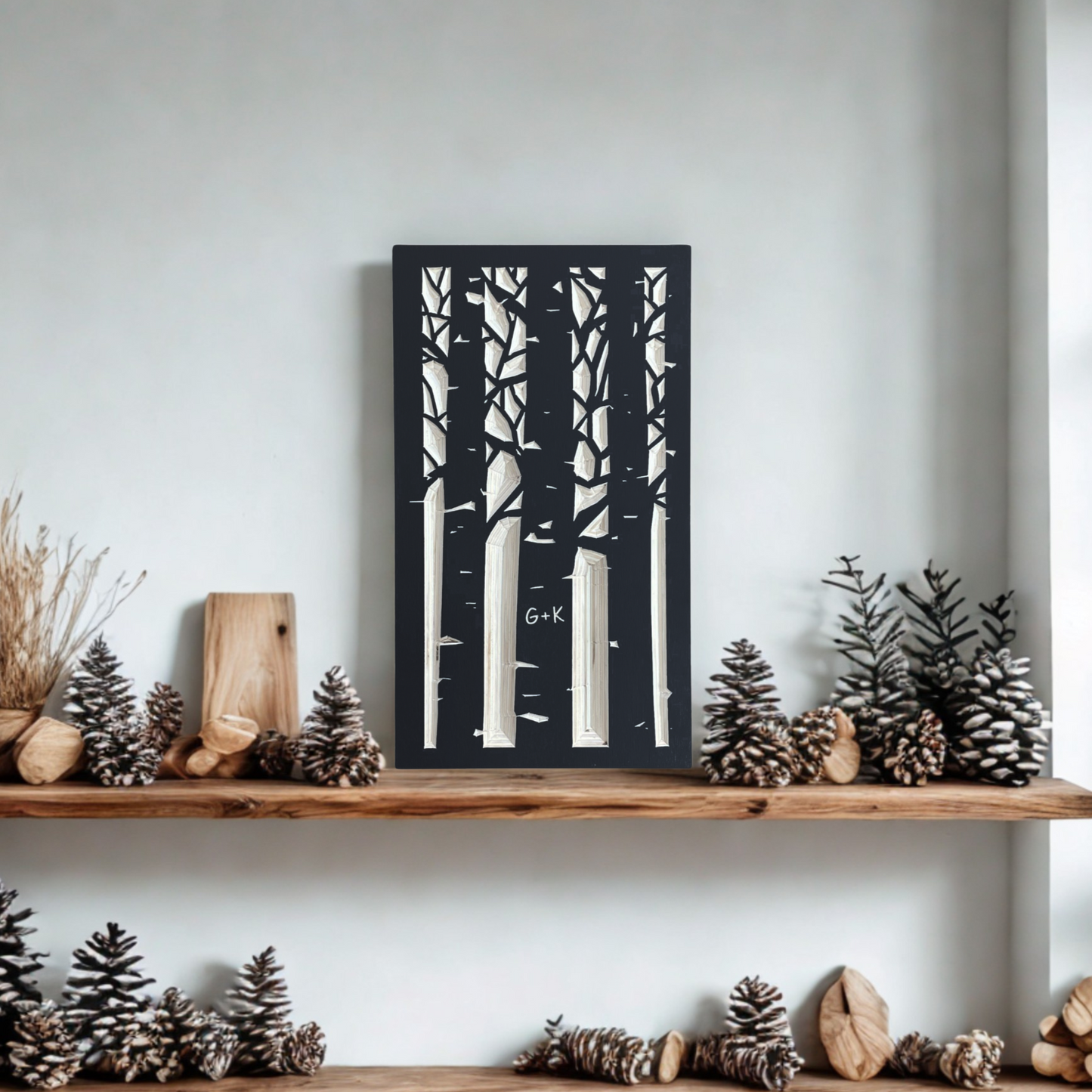Wooden shelf with decorative items including a carved aspen forest design against a white wall.