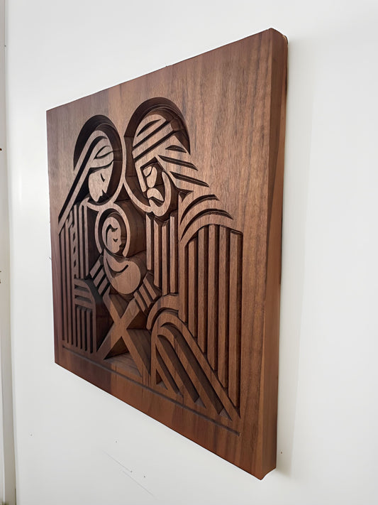 Side view of wooden relief of the Nativity scene on a white wall