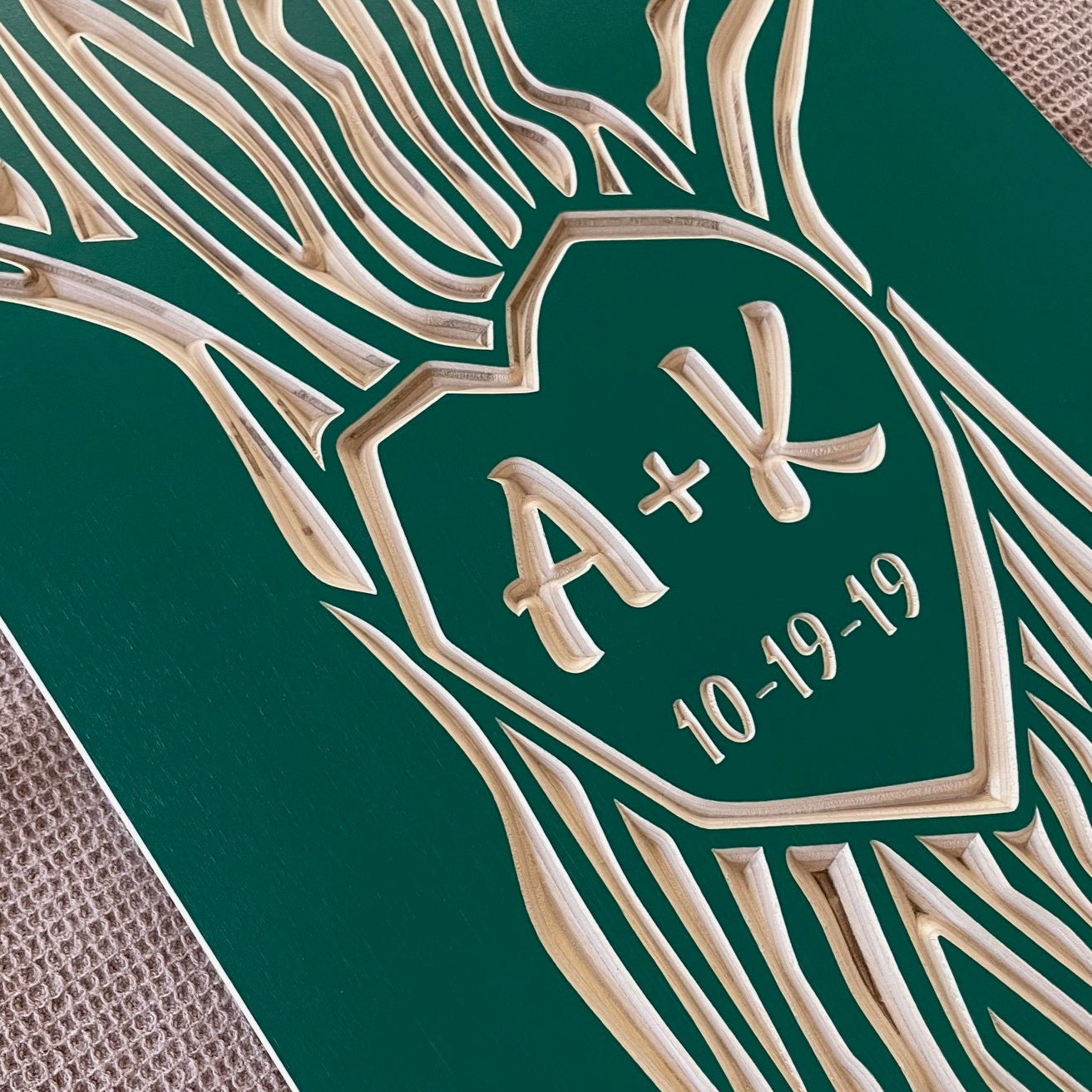 closeup of initials and wedding date carved in tree art. teal color.