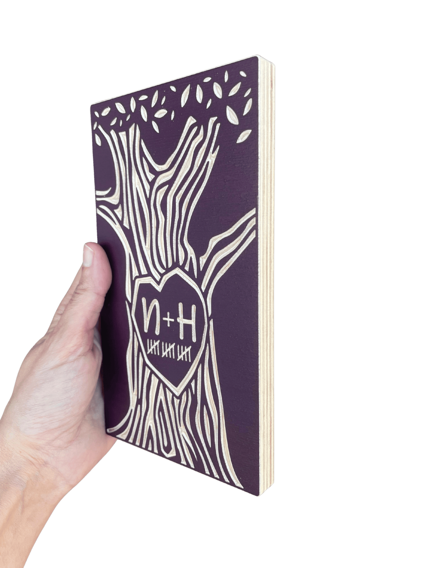 Hand holding a burgundy 15 year anniversary tree on a white background