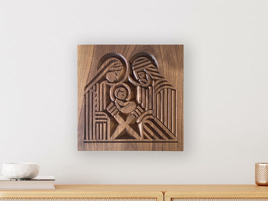 Wall hanging of Mary, Joseph, and infant Jesus carved block print style on walnut wood.