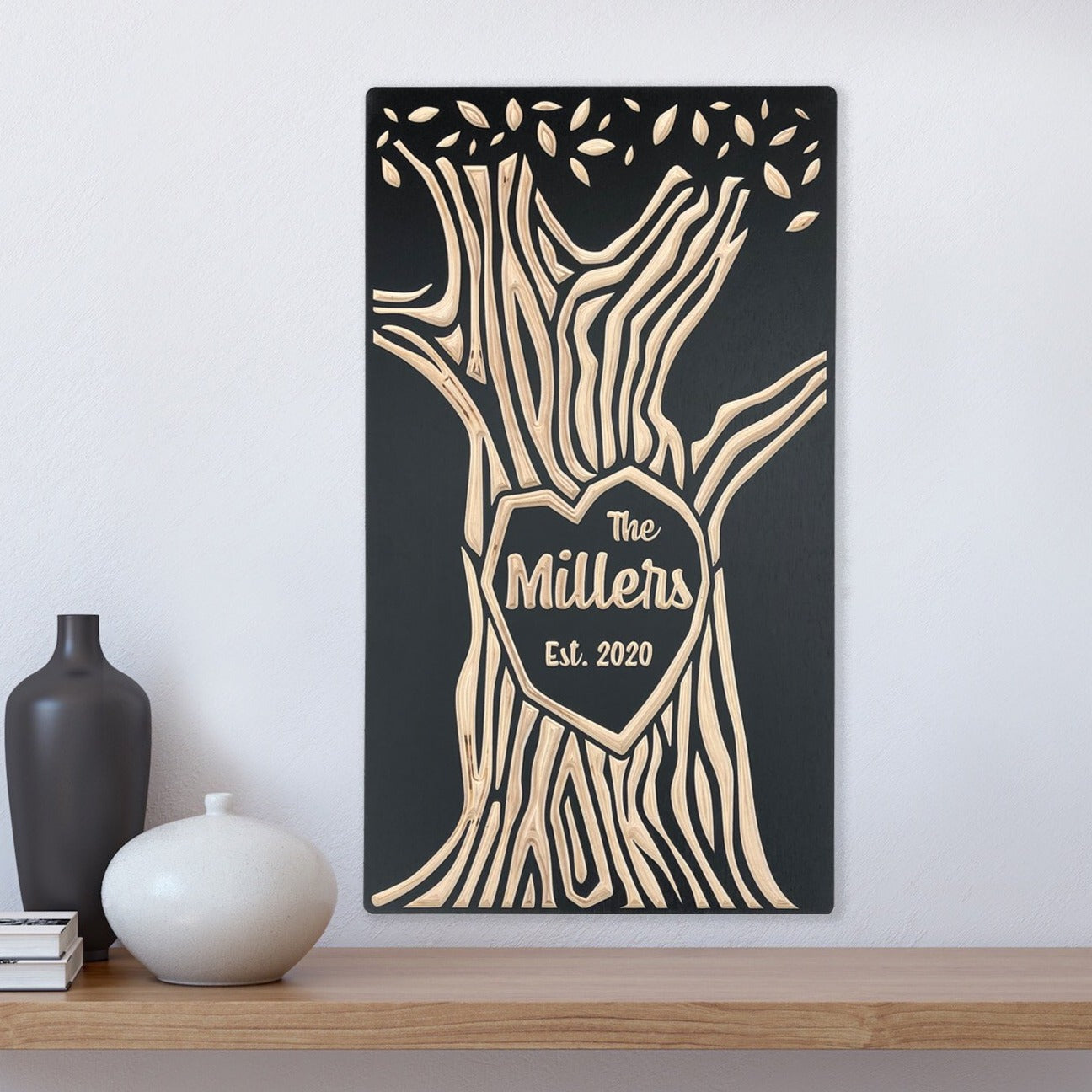 Handcrafted wooden wall art featuring a stylized tree design with a heart at its center, personalized with the family name and established date, displayed in a black finish.