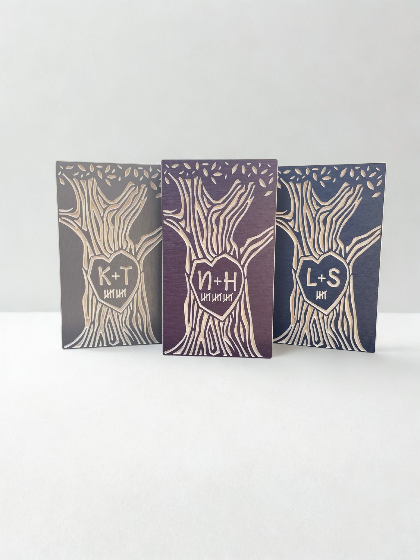 Three personalized anniversary trees, free-standing on a white background