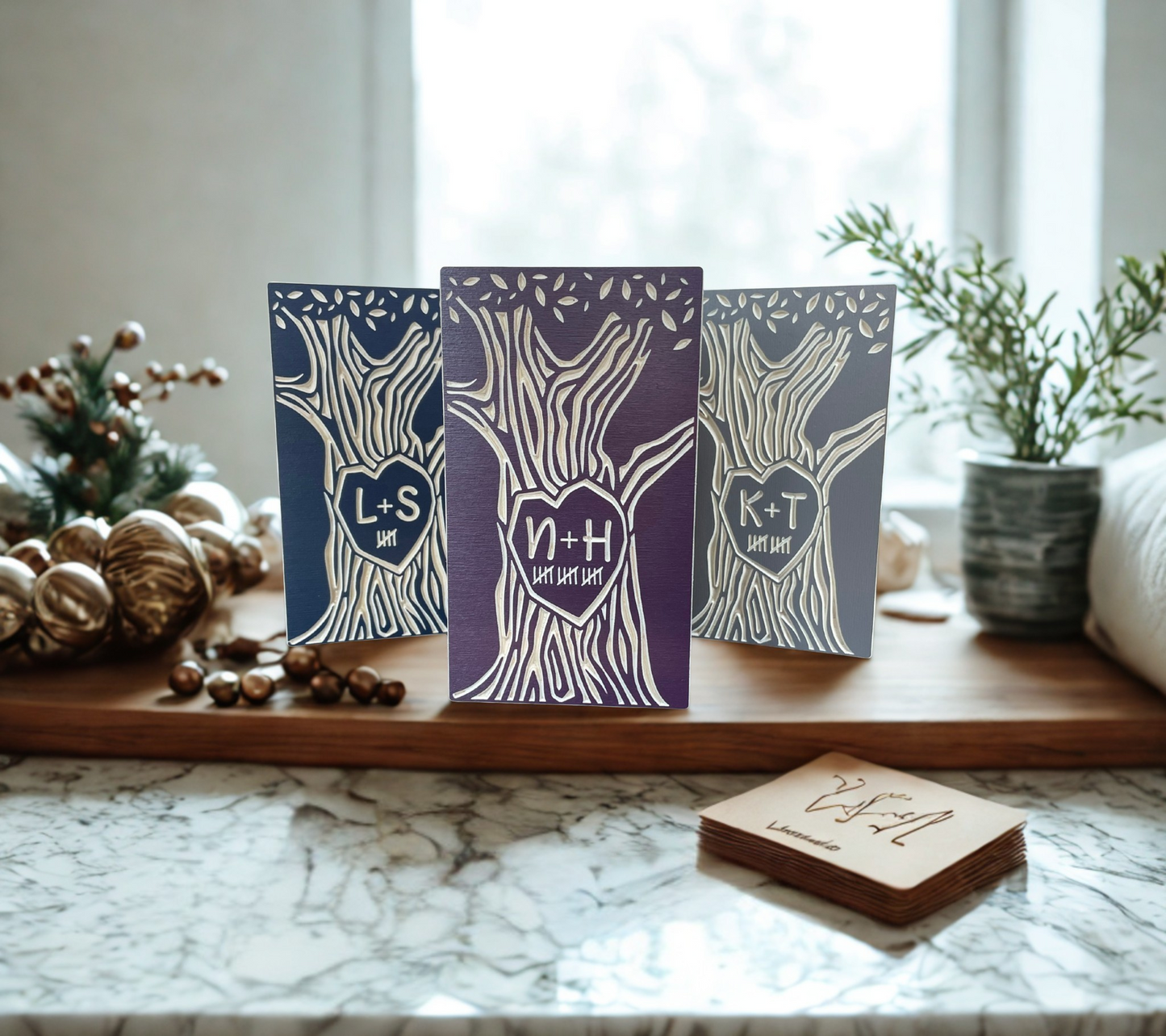 Three personalized wood couple trees on a marble surface with decorative elements.