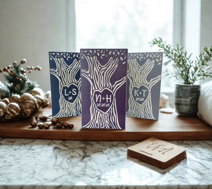 Three personalized wood couple trees on a marble surface with decorative elements.