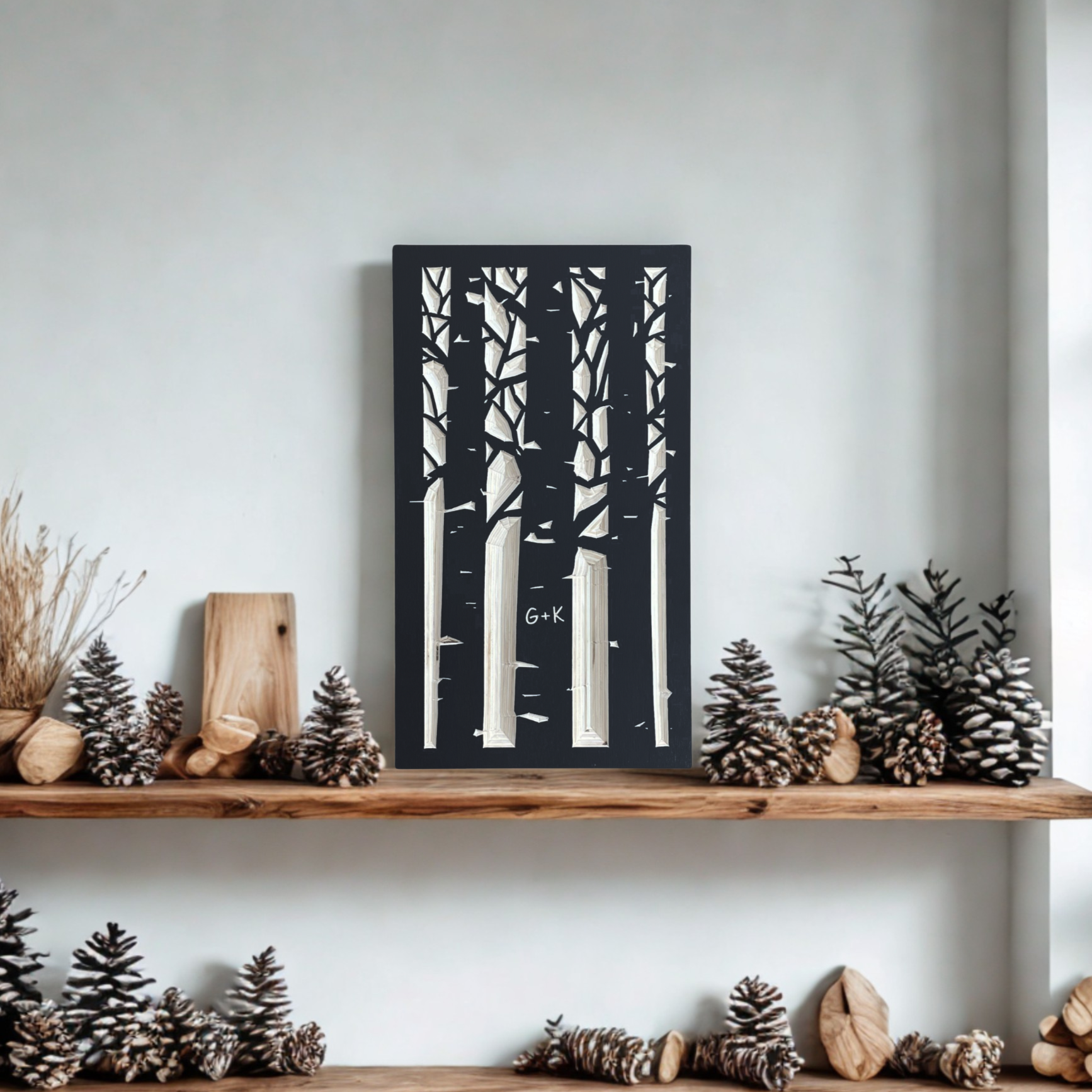 Wooden shelf with decorative items including a carved aspen forest design against a white wall.