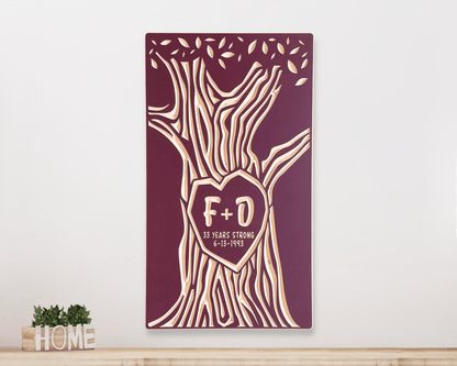 Decorative wall art with carved tree design and 'F+D' initials on a burgundy background, displayed hanging above a shelf.