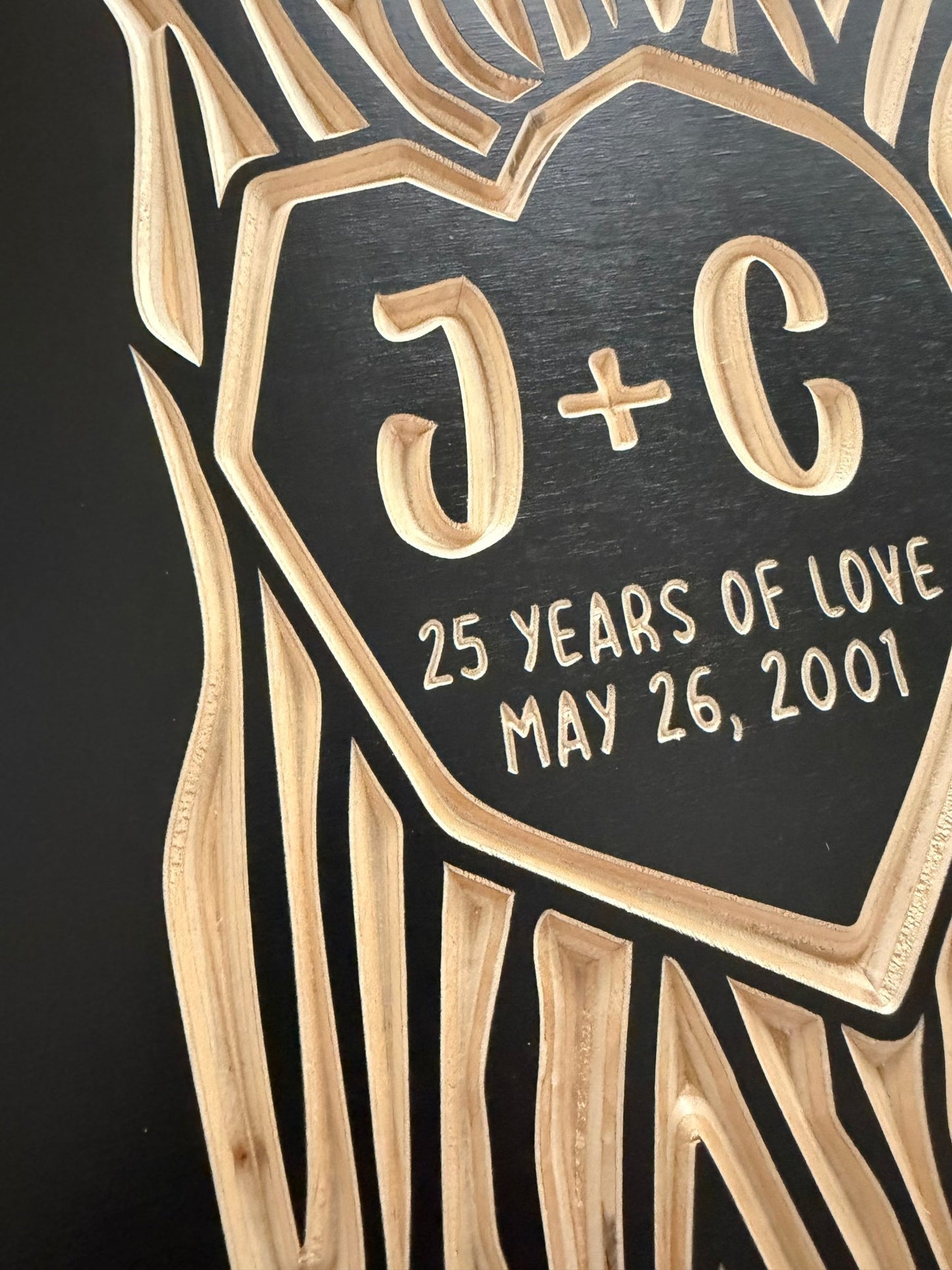 Decorative anniversary plaque with '25 Years of Love' text and dates on a black background.