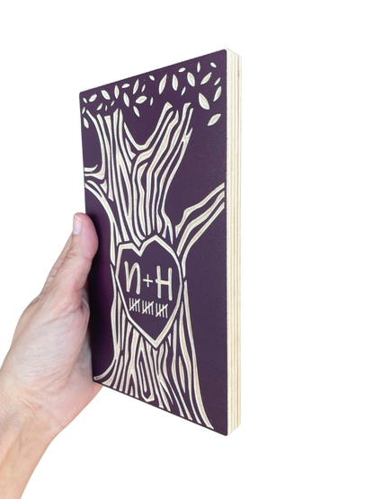 Hand holding a burgundy 15 year anniversary tree on a white background