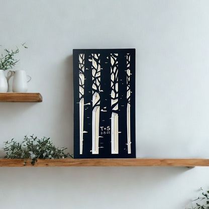 Wooden shelf with decorative items and a carved wooden artwork of trees on a white wall.