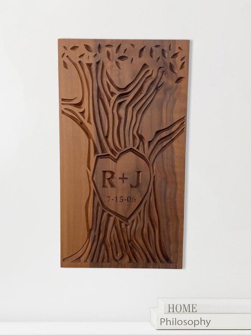 Hanging view of carved wall art with initials and wedding date carved into the trunk of a tree design. Artwork is carved on a solid walnut wood panel