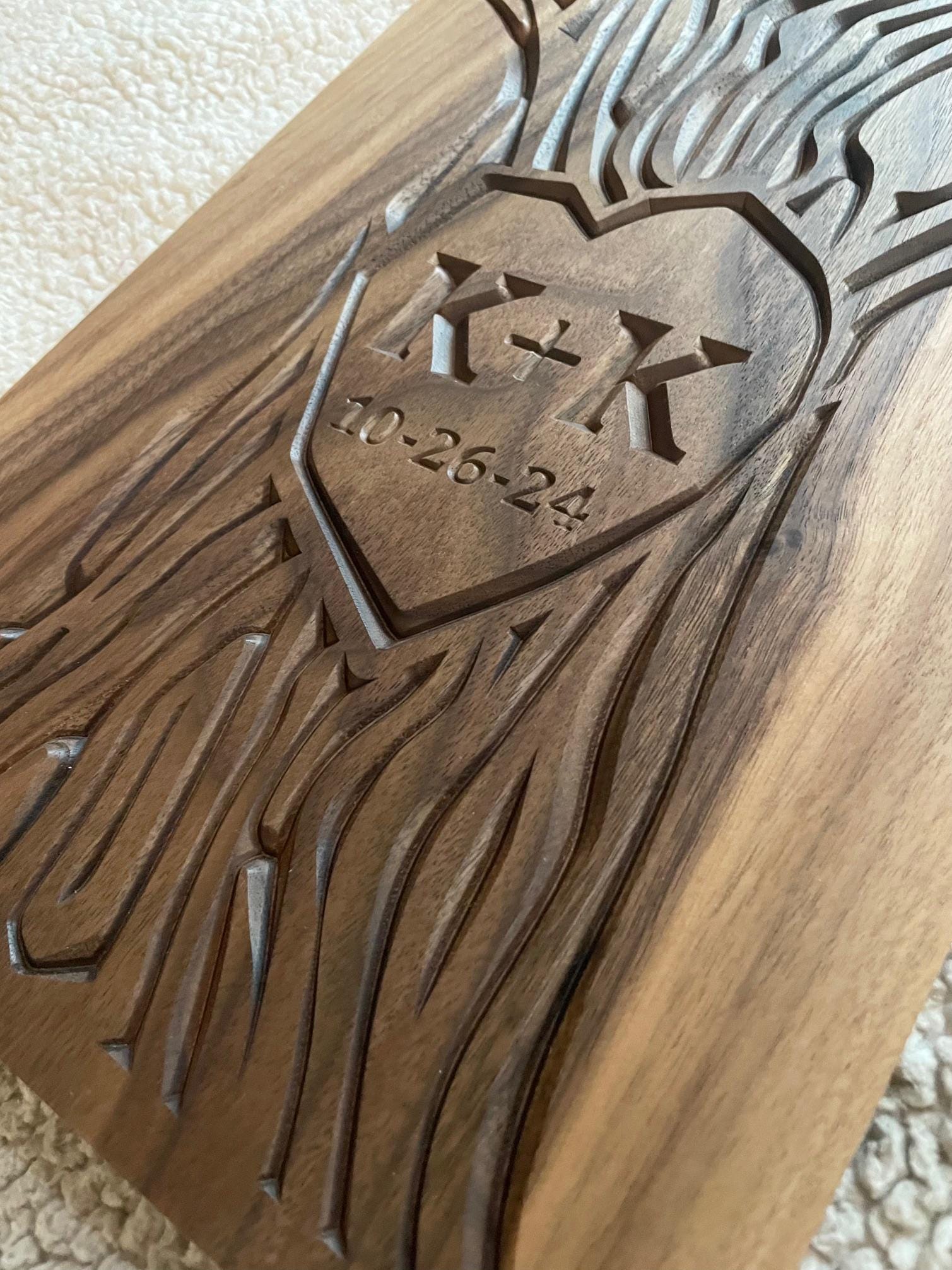 Detailed view of carved wall art with initials and wedding date carved into the trunk of a tree design. Artwork is carved on a solid walnut wood panel