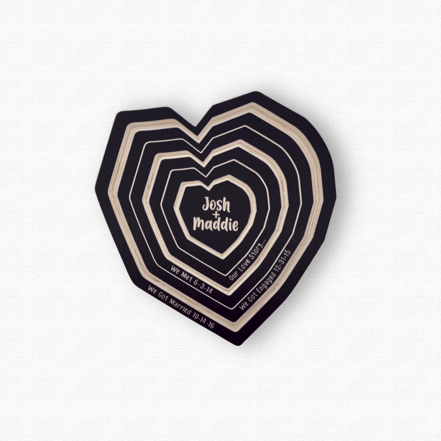 Our Love Story Wall Art, Personalized Wood Tree Ring Heart with we met, got engaged, and married dates. Shown in black finish on white background.