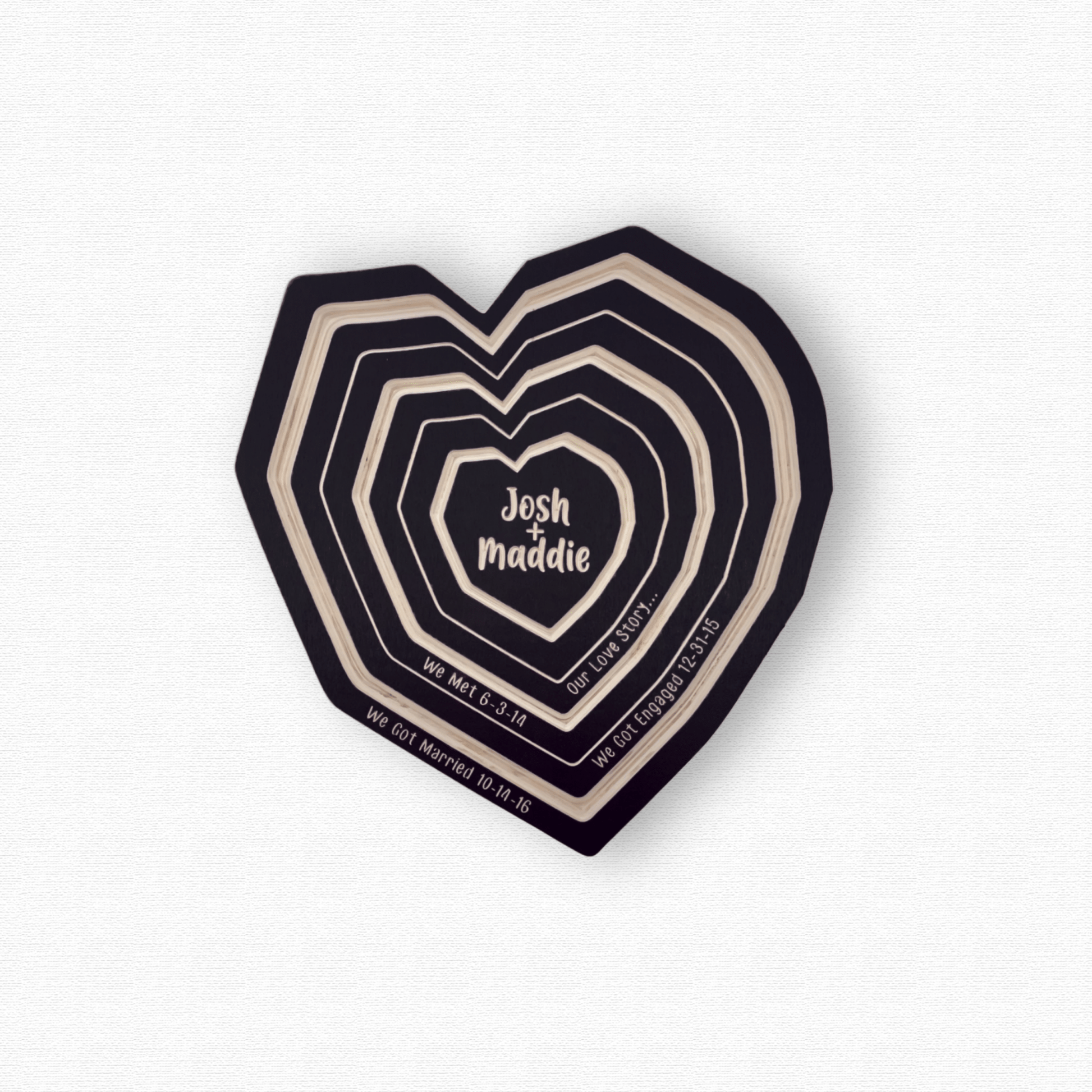 Our Love Story Wall Art, Personalized Wood Tree Ring Heart with we met, got engaged, and married dates. Shown in black finish on white background.