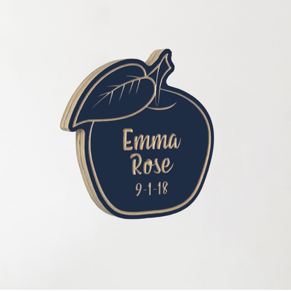 Side view of customized wooden apple with name and birthday. Shown in dark navy color.