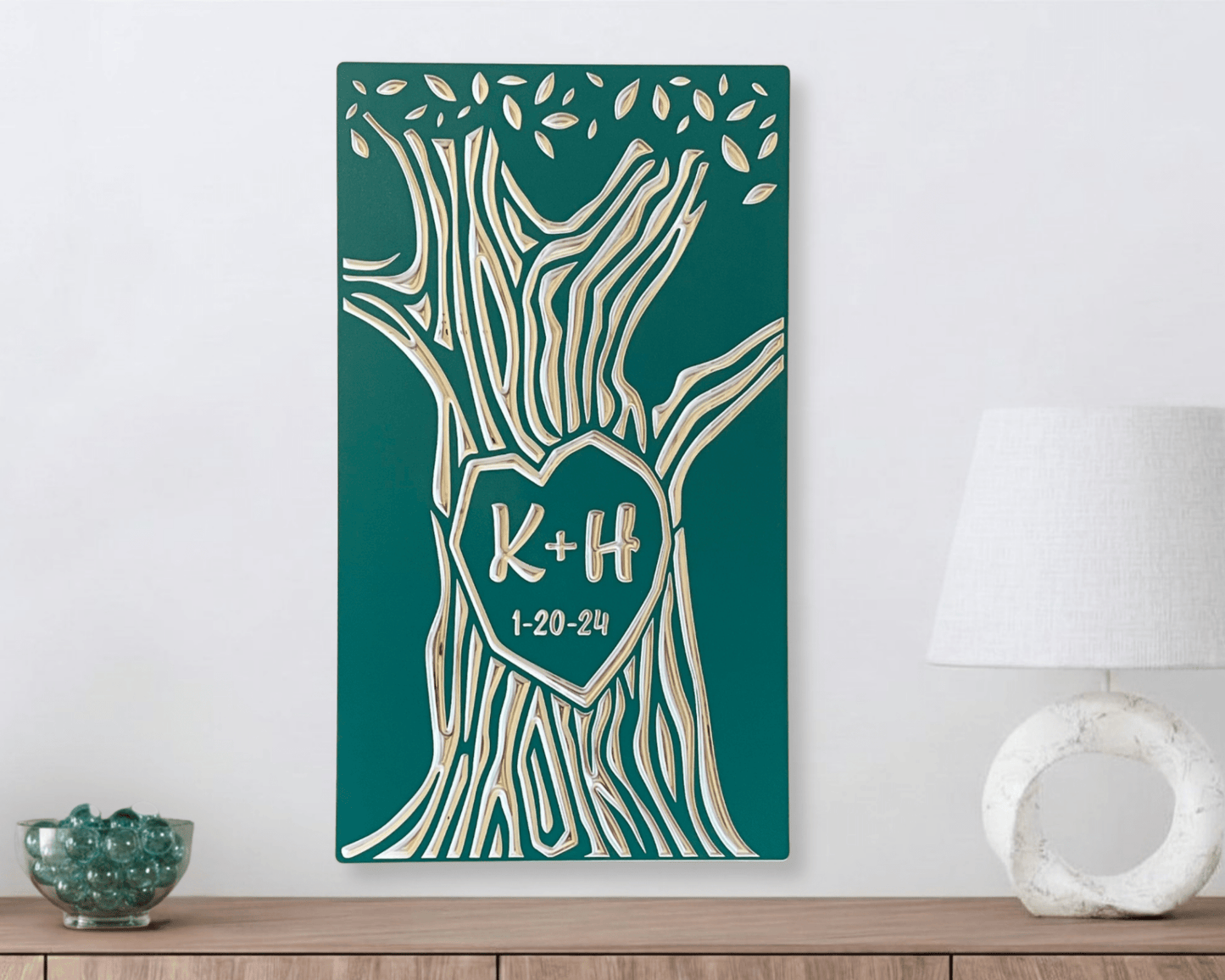 Decorative wall art with tree design and personalized text on a teal background, placed on a wooden surface.