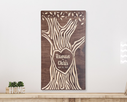Wooden wall art with tree design and engraved names on a white wall, walnut stain option.